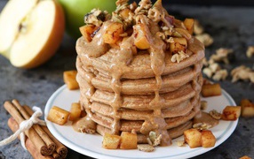 Вкусные оладьи с соусом и фруктами на столе с корицей