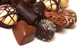 Разные шоколадные конфеты на белом фоне 