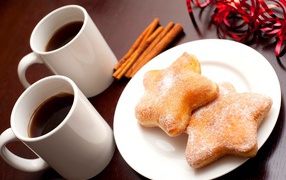 Donuts on the table with coffee and cinnamon sticks
