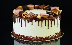 Праздничный торт украшен сладостями на черном фоне