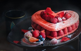 Heart-shaped cake with raspberry berries and powdered sugar