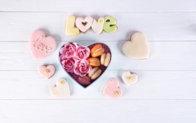 Печенье в форме сердца на столе с коробкой с десертом макарун