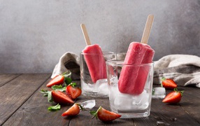 Фруктовое мороженое в стакане со льдом на столе с клубникой