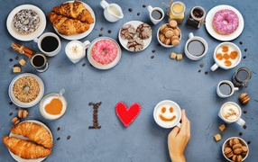 Много сладкой выпечки с кофе на сером фоне