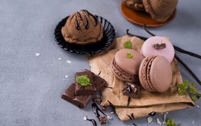 Печенье макарун на серой поверхности с мороженым и шоколадом