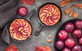 Pie on the table with pink large plums