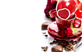 Красные чашки на белом фоне с шоколадными конфетами и кофейными зернами