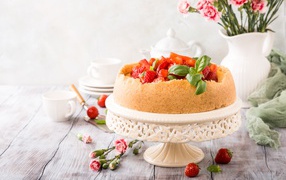 Песочный пирог с клубникой на столе с цветами гвоздики