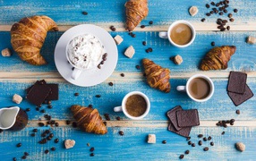 Сладости с кофе на голубом столе