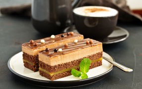 Два пирожных на тарелке с чашкой кофе 