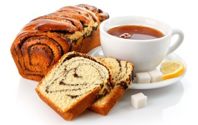 Белая чашка чая на белом фоне с кексом