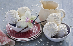 Белый зефир на столе с цветком орхидеи