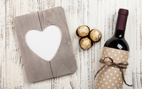 Бутылка вина на столе с конфетами и сердцем 