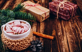 Чашка какао с маршмеллоу на столе с подарками