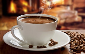 Большая белая чашка с горячим кофе на столе с кофейными зернами