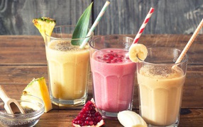 Три стакана смузи на столе с трубочками