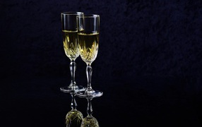 Two glasses with champagne on a black background