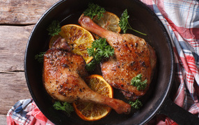 Куриные окорочка в сковороде с кольцами апельсина и петрушкой