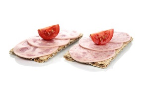 Toasts with sausage and slices of tomato on a white background