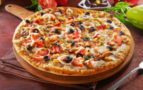 Big pizza on the board with olives and tomatoes