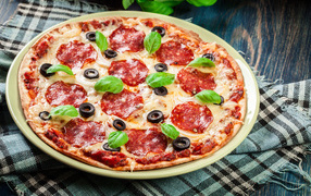 Пицца с сыром и салями на столе 