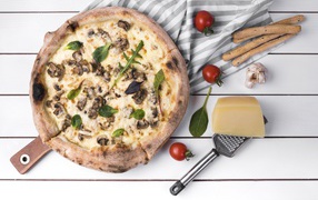 Pizza with mushrooms on the table with cheese and vegetables