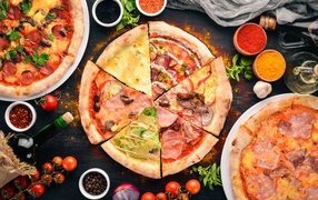 Pizza with various fillings on the table with spices
