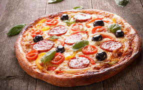 Rosy pizza with sausage, tomatoes, olives and cheese