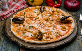 Tasty pizza with seafood on a wooden board