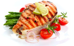 Кусок жареной рыбы с овощами на белом фоне 