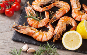 Boiled shrimps on the table with lemons and tomatoes
