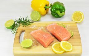 Красная рыба на разделочной доске с лимоном и перцем 