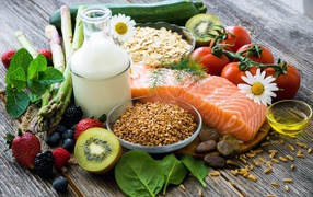 Кусок красной рыбы на столе с ягодами и овощами