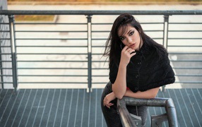 Красивая девушка стоит на ступеньках у перил 