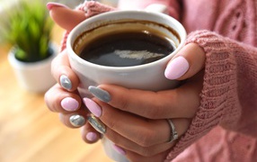 Чашка кофе в руках у девушки с маникюром