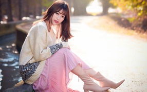 Девушка азиатка сидит на земле 