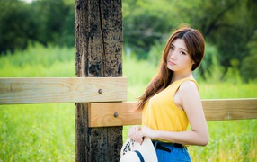 Красивая азиатка у деревянного столба 