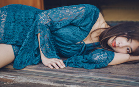 Красивая девушка азиатка в платье лежит на полу