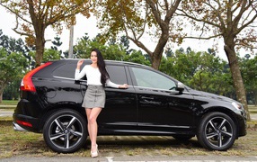 Красивая девушка азиатка у черного автомобиля