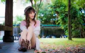 Красивая девушка азиатка сидит на земле 