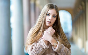 Красивая голубоглазая блондинка в теплом свитере с часами на руке