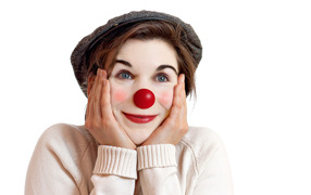 Beautiful blue-eyed girl in a cap with a clown nose on a white background