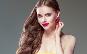 Красивая голубоглазая девушка с длинными волосами на сером фоне