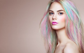 Красивая голубоглазая девушка с разноцветными волосами на сером фоне