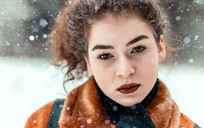 Красивая кареглазая девушка стоит на улице зимой