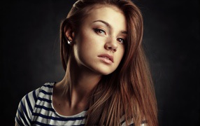 Красивая кареглазая девушка с русыми волосами на сером фоне