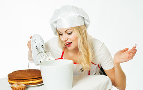 Красивая девушка повар взбивает крем для торта миксером