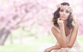 Beautiful girl in a pink dress with a wreath on her head