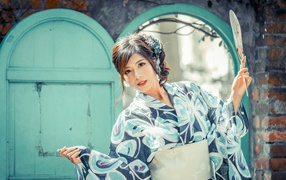 Красивая девушка в кимоно с веером в руке