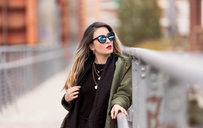 Красивая девушка в солнечных очках на мосту